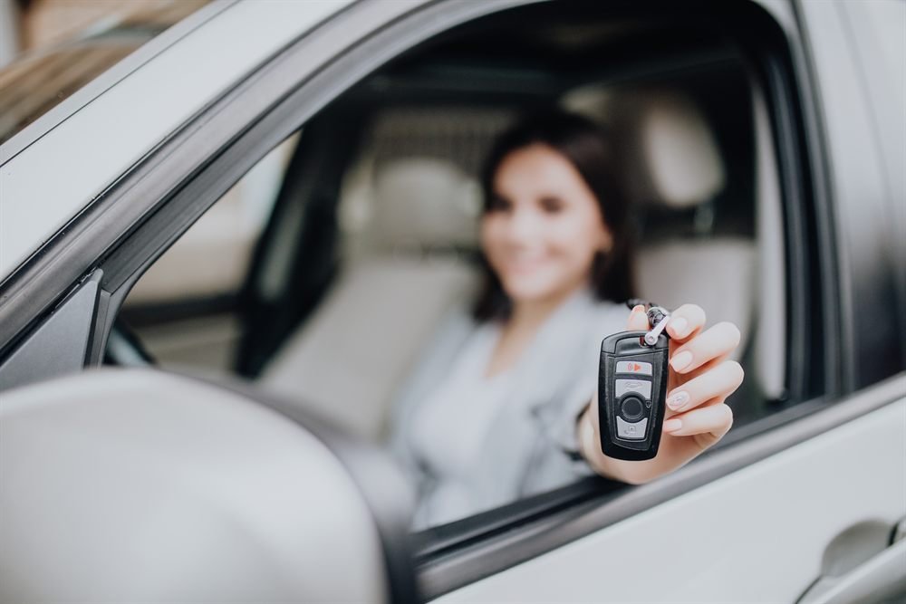 Cliente satisfaite tenant la clé de son véhicule après intervention Expert Clés Auto